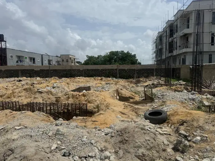 Crescent excavation and foundation work in the foreground, neighbouring buildings beyond the site, April 2026